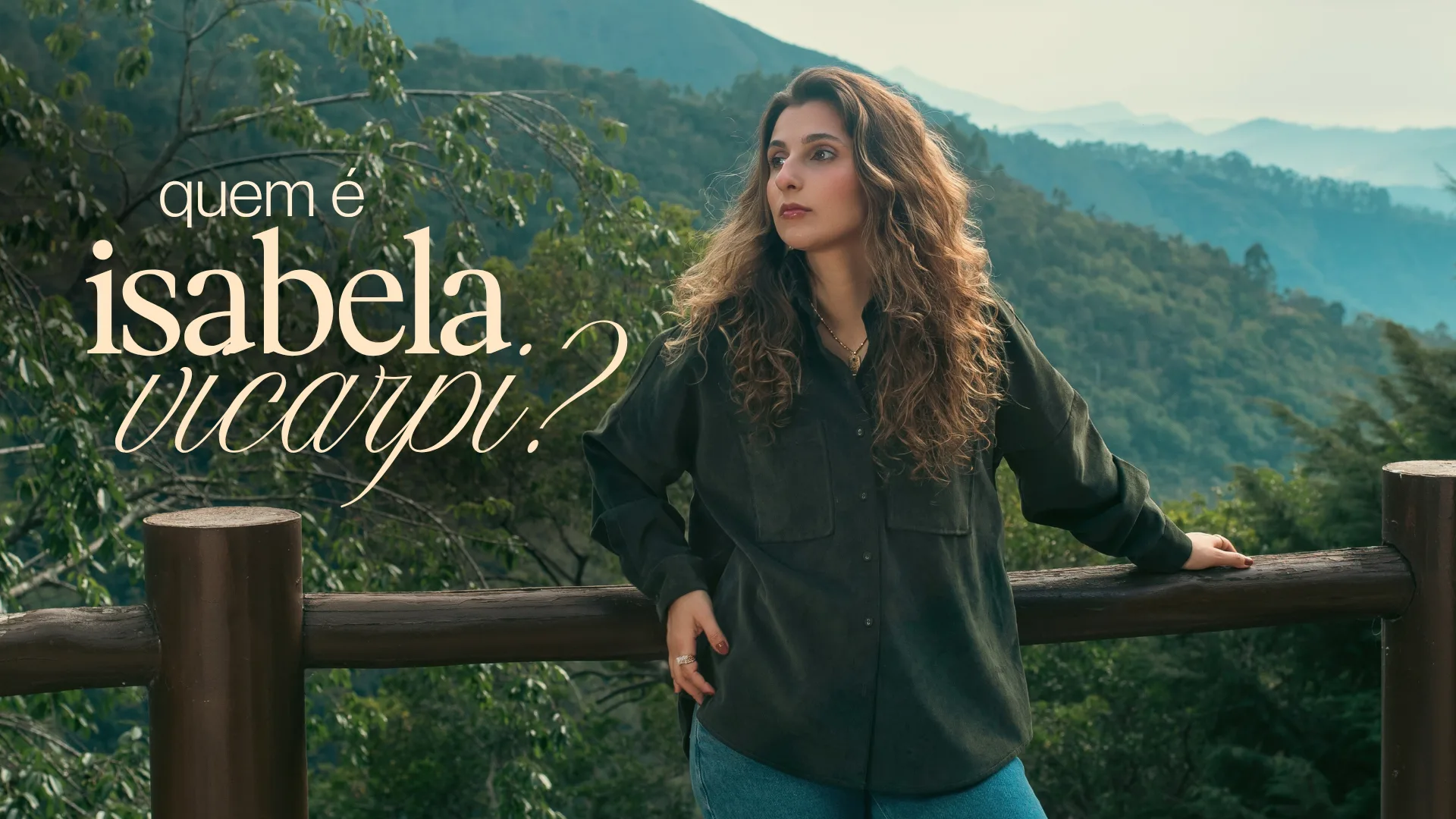 Quem é Isabela Vicarpi? Isabela encostada numa cerca de madeira, com as montanhas ao fundo